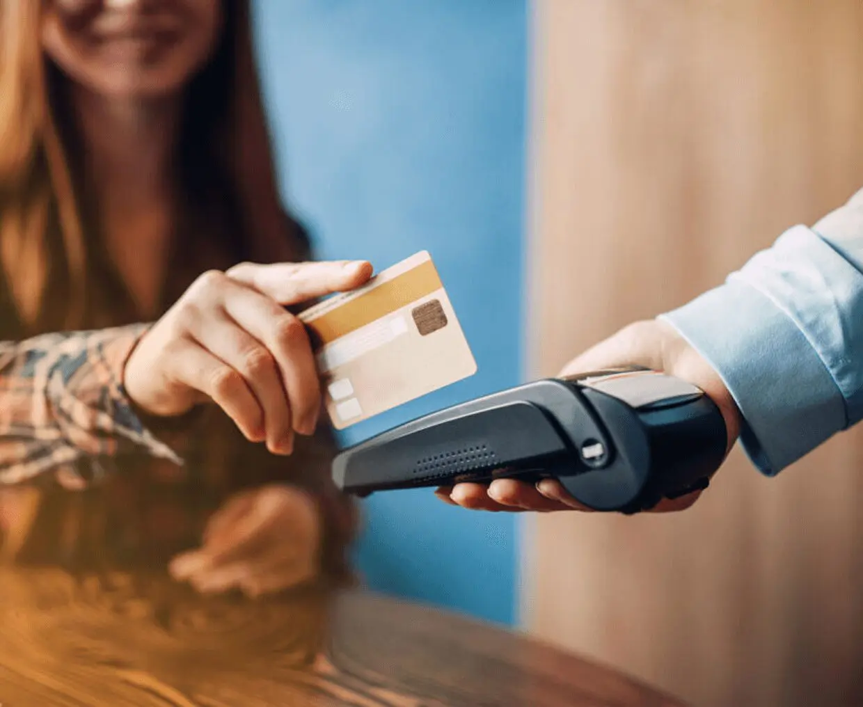Woman using contactless payment with card.
